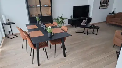 a dining room with a black table and chairs at Gezellig appartement Beveren Kruibeke Zwijndrecht Donkvijver in Beveren