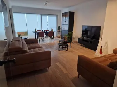 a living room with a couch and a television at Gezellig appartement Beveren Kruibeke Zwijndrecht Donkvijver in Beveren