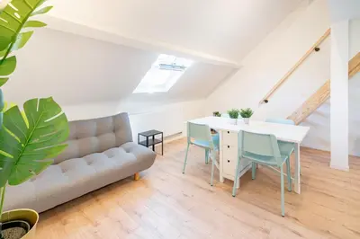 a living room with a couch and a table and chairs at Charming Central Cityflats in Antwerp