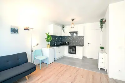 a living room with a blue couch and a kitchen at Charming Central Cityflats in Antwerp