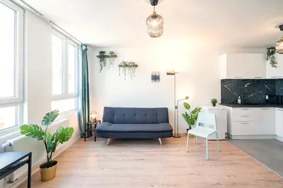 a living room with a blue couch and a kitchen at Charming Central Cityflats in Antwerp