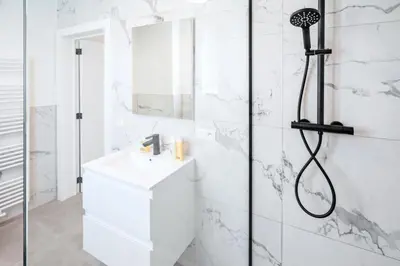 a white bathroom with a shower and a sink at Charming Central Cityflats in Antwerp