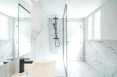 a white bathroom with a shower and a sink at Charming Central Cityflats in Antwerp