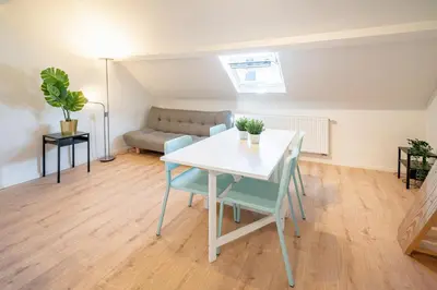 a living room with a table and chairs and a couch at Charming Central Cityflats in Antwerp