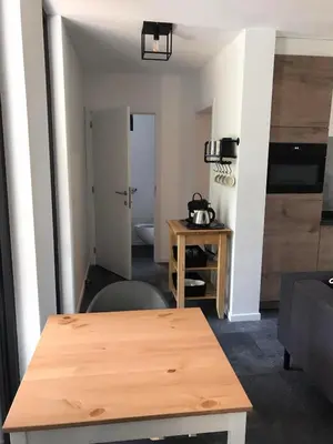 a living room with a table and a kitchen at Vakantiewoning De Kleine Duinberg - Chalet Nr 9 in Retie