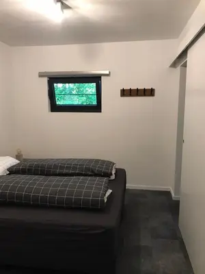 a bedroom with a bed and a window at Vakantiewoning De Kleine Duinberg - Chalet Nr 9 in Retie