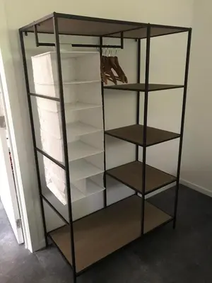 a black bookcase with shelves in a room at Vakantiewoning De Kleine Duinberg - Chalet Nr 9 in Retie