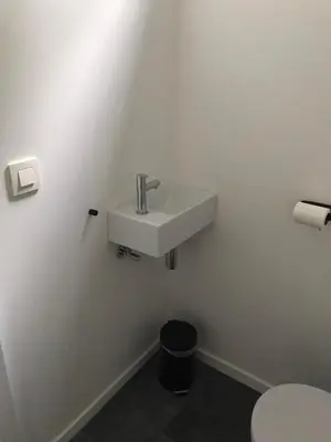 a white bathroom with a sink and a toilet at Vakantiewoning De Kleine Duinberg - Chalet Nr 9 in Retie