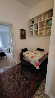 a room with a table with a flowered table cloth at Cozy studio close to Zaventem Airport in Brussels