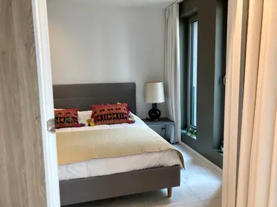 a bedroom with a bed with red pillows and a window at Apartment in the Heart of Ghent in Ghent