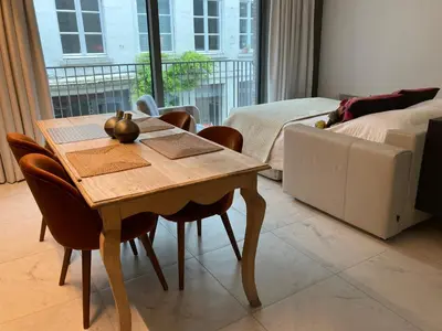 a dining room with a table and chairs and a bed at Apartment in the Heart of Ghent in Ghent