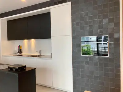 a kitchen with white cabinets and a window at Apartment in the Heart of Ghent in Ghent