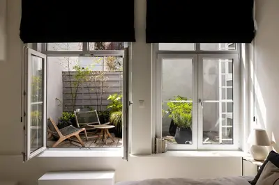 a room with two windows and a table and chairs at LuxuryApartmentSoulforCity in Ghent