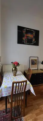a dining room table with a vase of flowers on it at Bright studio close to Zaventem airport in Brussels