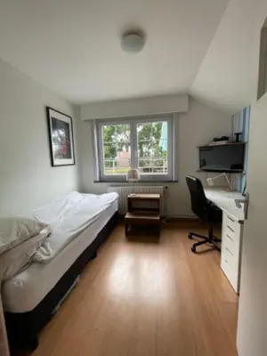 a bedroom with a bed and a desk and a chair at Great house 5' from Tomorrowland in Rumst