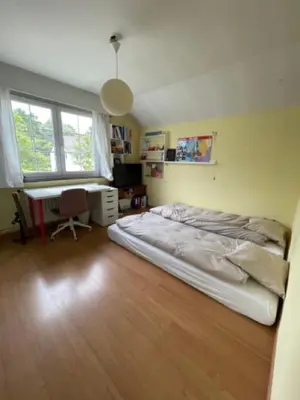 a bedroom with a bed and a desk in it at Great house 5' from Tomorrowland in Rumst