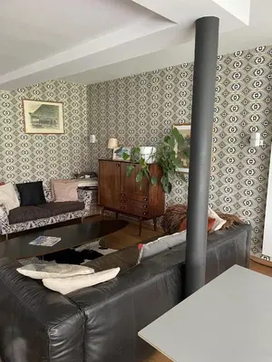 a living room with a black leather couch at Great house 5' from Tomorrowland in Rumst