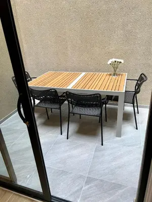 a wooden table and chairs with a vase of flowers at Exclusive two-level apartment with private terrace on the canal Brussels in Brussels