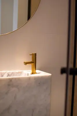 a bathroom sink with a gold faucet in front of a mirror at B&b kleinen bosch in Beveren