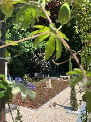 a garden with purple flowers and a bench in the background at B&b kleinen bosch in Beveren