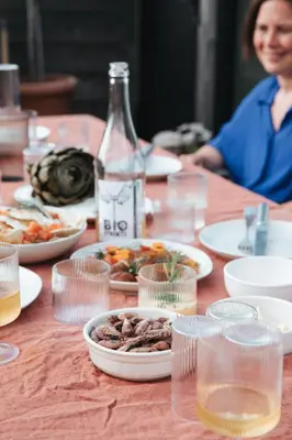 a table with plates of food and a bottle of wine at Pañ boetiek BnB in Zele