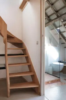 a wooden staircase in a room with a toilet at Pañ boetiek BnB in Zele