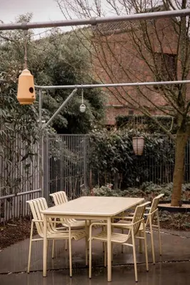 a table and chairs in a yard with a fence at KROOST in Lokeren