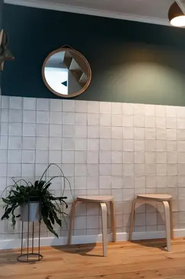 a mirror and two stools in a waiting room at KROOST in Lokeren