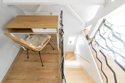 a staircase with a desk and a chair in a room at KROOST in Lokeren