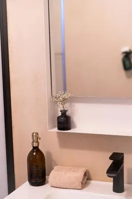 a bottle of soap sitting on a bathroom sink at KROOST in Lokeren