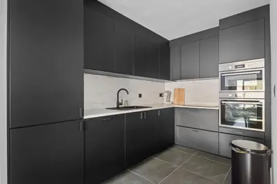 a kitchen with black cabinets and a sink at Lappertemento in Willebroek