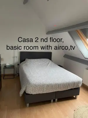 a bedroom with a bed in a room with a window at Casa Christel in Mechelen