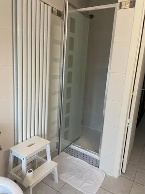 a shower stall with a stool in a bathroom at Casa Christel in Mechelen
