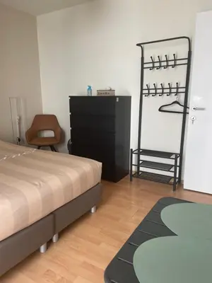 a bedroom with a bed and a dresser and a chair at Casa Christel in Mechelen
