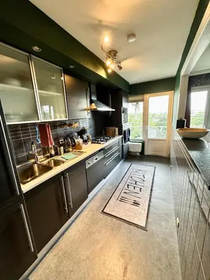 a kitchen with black cabinets and a sink at Hearth of Brussels Gateway in Brussels