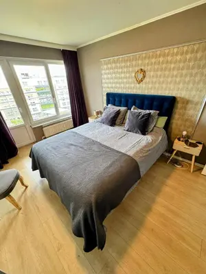 a bedroom with a large bed with a blue headboard at Hearth of Brussels Gateway in Brussels