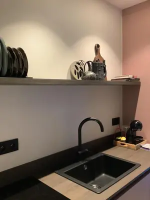 a kitchen counter with a sink and a shelf at Via Caput in Lokeren