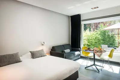 a bedroom with a bed and a table and a chair at Marcel de Gand Business & Travel in Ghent