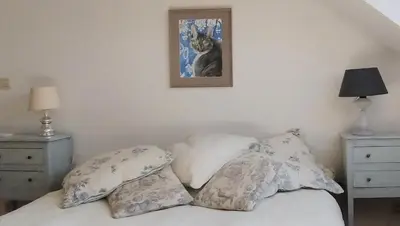 a bed with pillows and a picture on the wall at L Heure Bleue in Wezembeek-Oppem