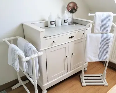 a white dresser with two chairs and a mirror at L Heure Bleue in Wezembeek-Oppem