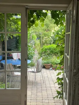 an open door to a patio with a table and chairs at L Heure Bleue in Wezembeek-Oppem