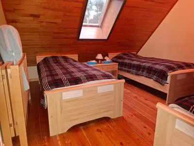 a attic room with two beds and a window at B&B Wepa-hof in Oud-Turnhout