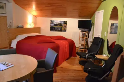 a bedroom with a bed and chairs and a table at B&B Wepa-hof in Oud-Turnhout