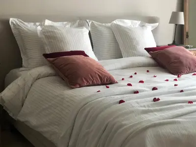 a white bed with red rose petals on it at NeNe in Dilbeek