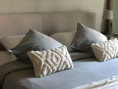 a bed with three pillows on top of it at NeNe in Dilbeek