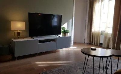a living room with a flat screen tv on a cabinet at BnB Antwerpen - CHIQUE in Antwerp