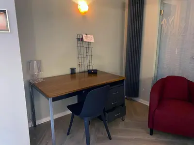 a desk in a room with a chair and a red chair at Belair Studio in Tervuren