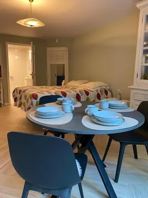a table with plates and cups on it in front of a bed at Belair Studio in Tervuren