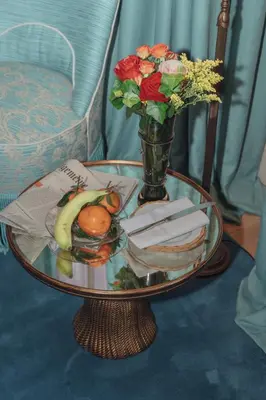 a glass table with a vase of flowers and a plate of food at Flora in Antwerp