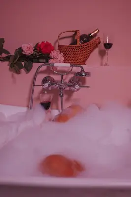 a bath tub with a basket of wine glasses and roses at Flora in Antwerp